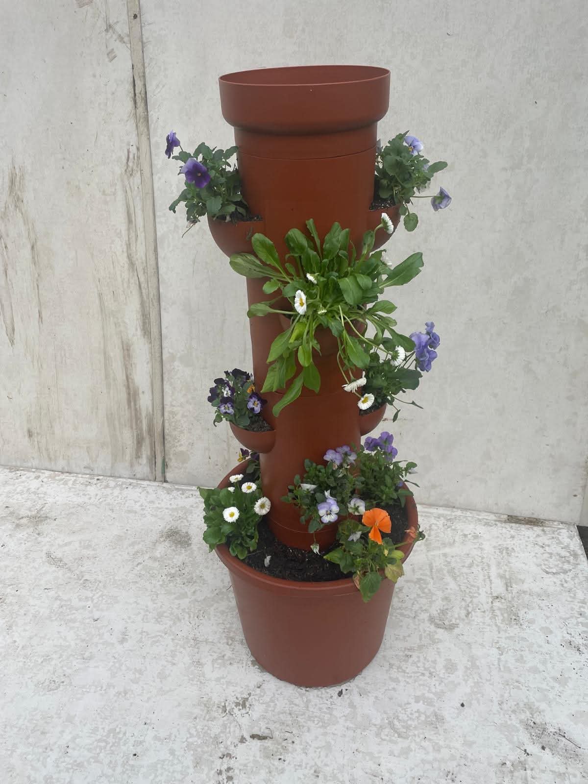 Planter tower filled with colourful violas, pansies, and cascading flowering plants